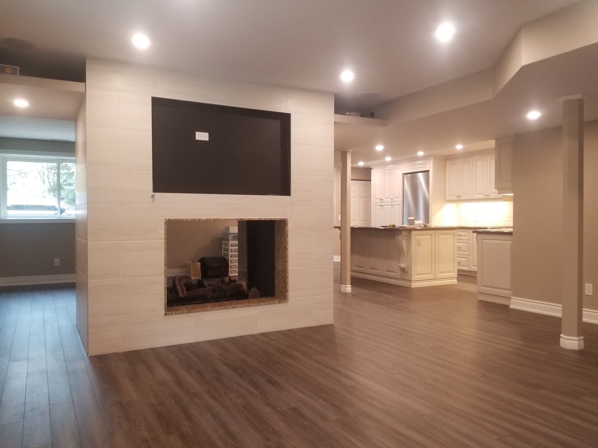 Open-concept basement with tiled fireplace
